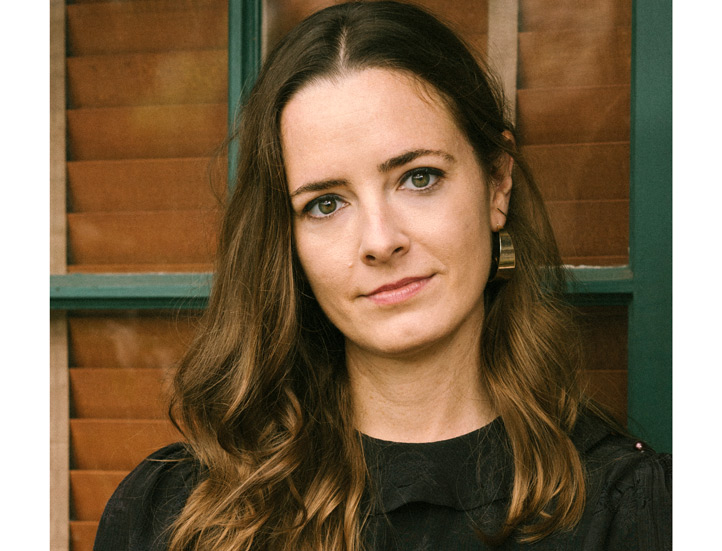 photo of event subject against some windows looking into camera with face filing the frame