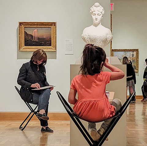 people sitting around a plaster bust sketching in the galleries