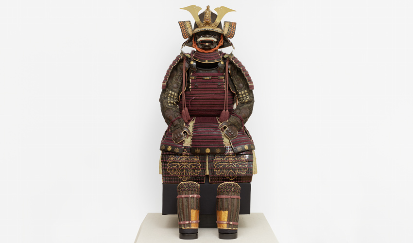 photo of Japanese suit of armor on display against an off white backdrop