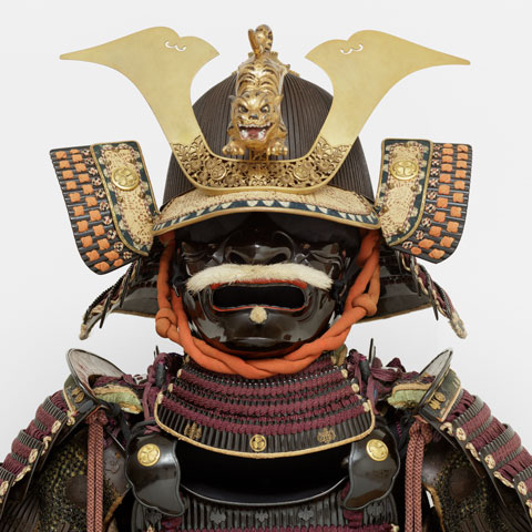 detail of a Japanese suit of armor helmet against an off white backdrop