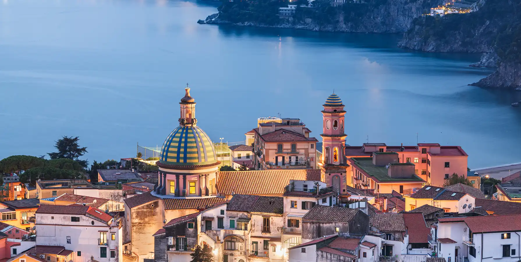 photo of buildings overlooking the water at dusk