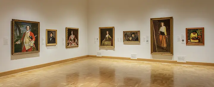 photo of a white wall with text next to an entrance to a gallery