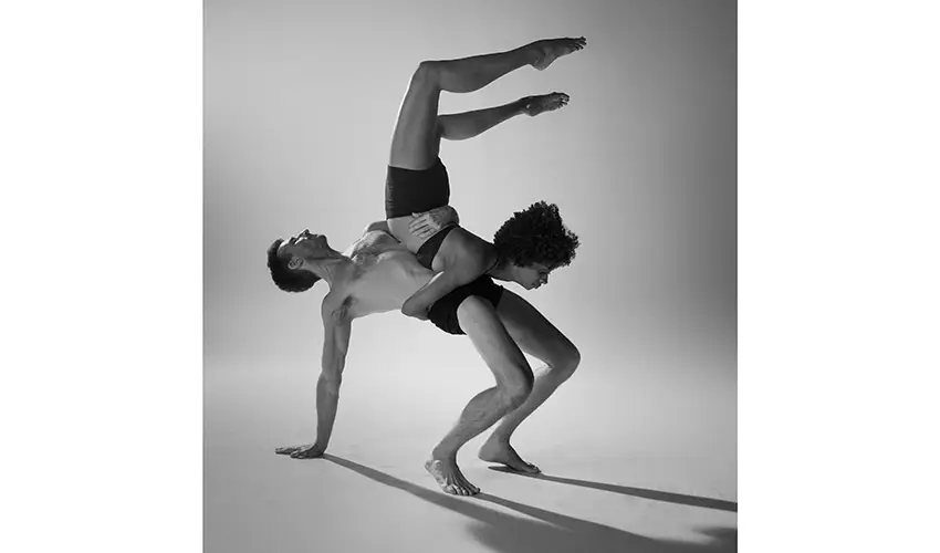 black and white photo of a couple performing modern dance on a white backdrop