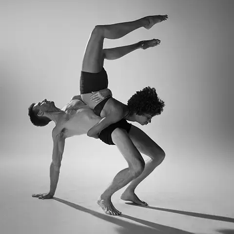black and white photo of a couple performing modern dance on a white backdrop