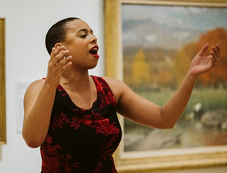 photo of opera singer in red dress singing in museum gallery