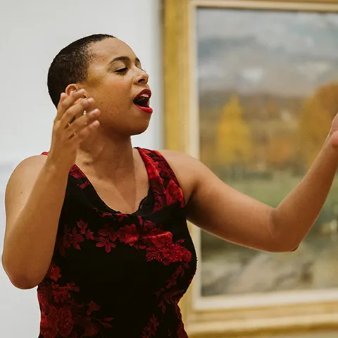 photo of opera singer in red dress singing in museum gallery