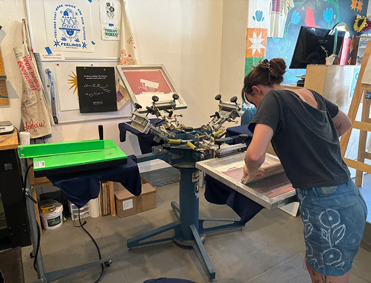 photo of someone using a screen printing machine