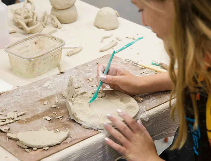 photo looking over the shoulder of student crafting at table