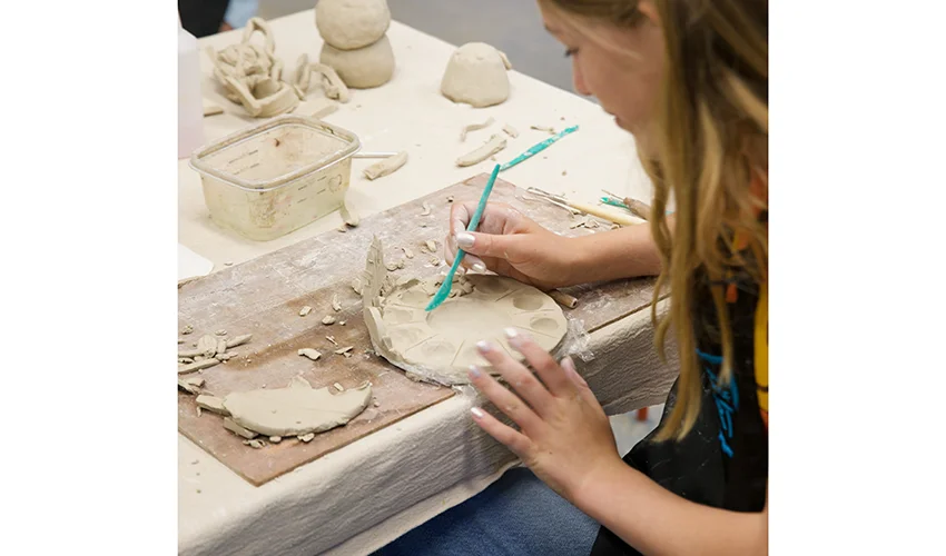photo looking over the shoulder of student crafting at table