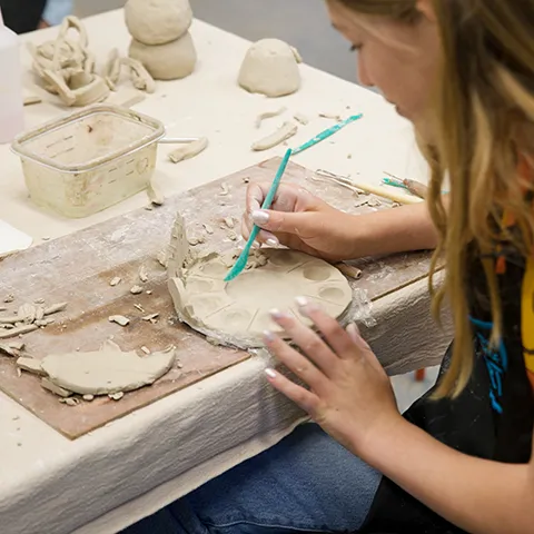 photo looking over the shoulder of student crafting at table