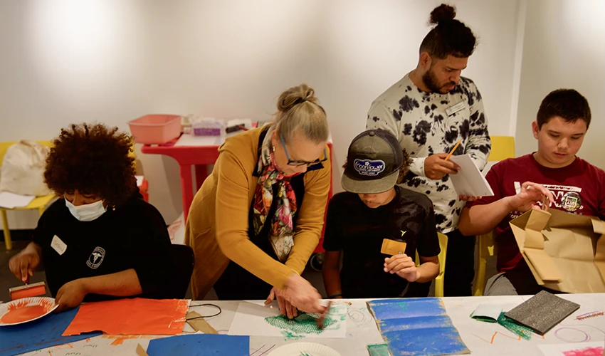 photo of instructor helping young people with crafts