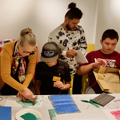 photo of instructor helping young people with crafts
