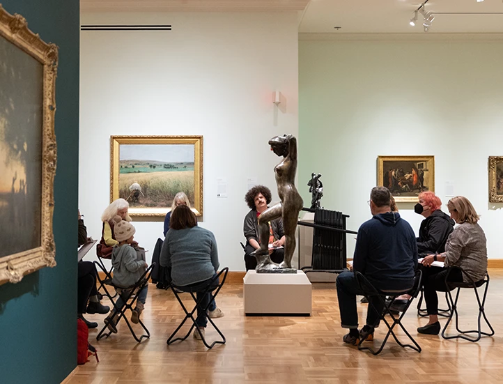 photo of people in a gallery sketching a sculpture