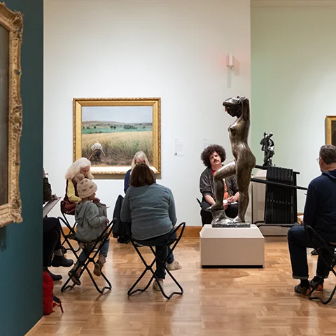 photo of people in a gallery sketching a sculpture