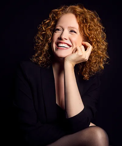 photo of presumably woman singer with red hair in black