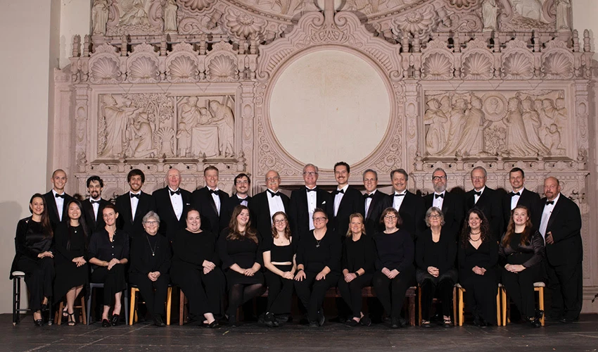 group of musicians in tuxedos seated and standing in a row for the camera