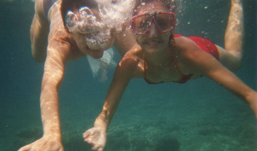 underwater photo showing two people swimming and facing the camera