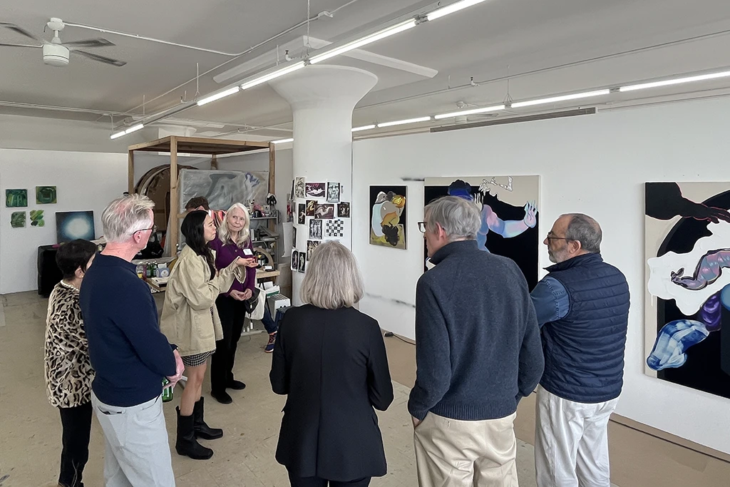 in a room surrounded by art people get a studio tour by an Asian artist