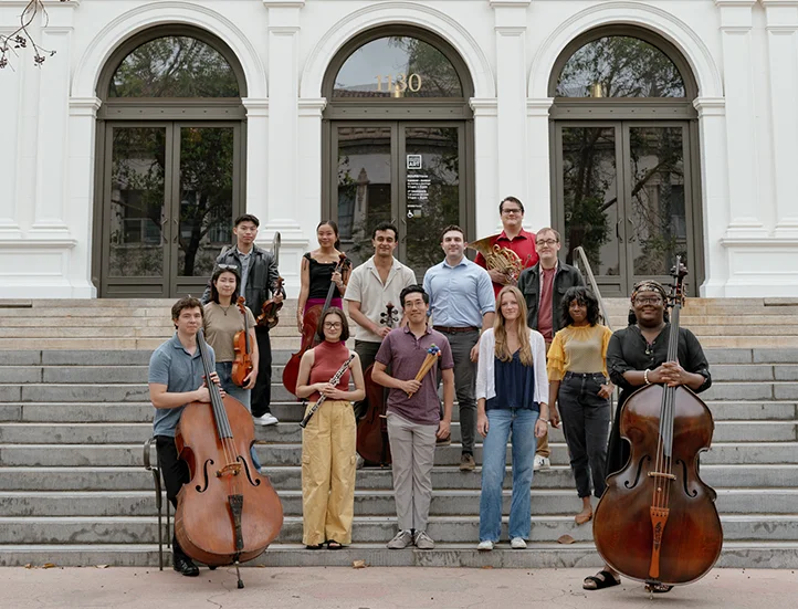 group of young people with their instruments standing on the front steps of the museum entrance