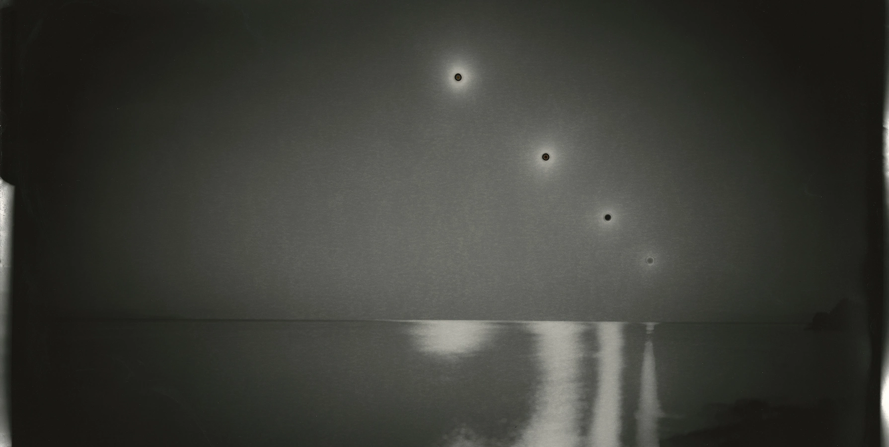 black and white photo of reflections in a body of water receding into the horizon