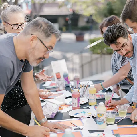 adults crafting at a long table