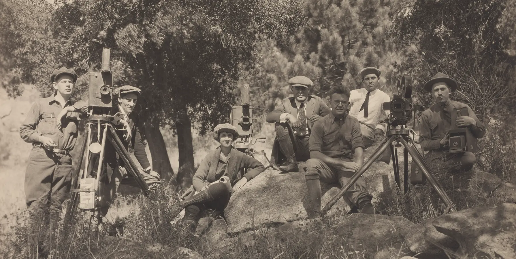 sepia toned print of group of men in the outdoors with their camera equipment.