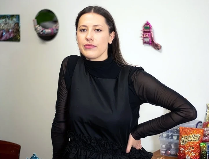 photo of a young white woman in a dark top looking at the viewer