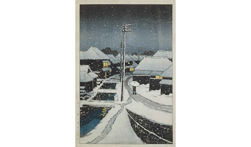 snowy street scene of early 20th century Tokyo at night with a figure walking down a path near a waterway and past some buildings lit from the inside
