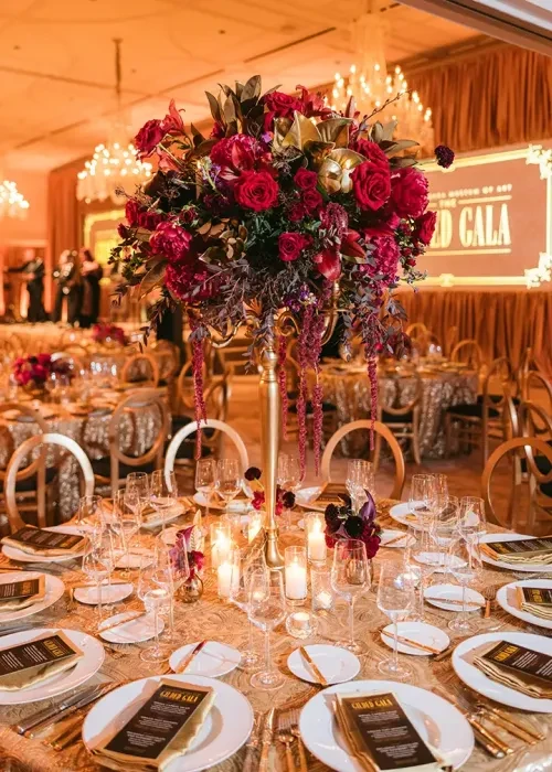 photo of round table at event with bouquet of flowers in the center surrounded by place settings