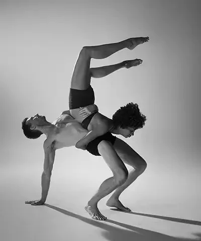 black and white photo of a couple performing modern dance on a white backdrop