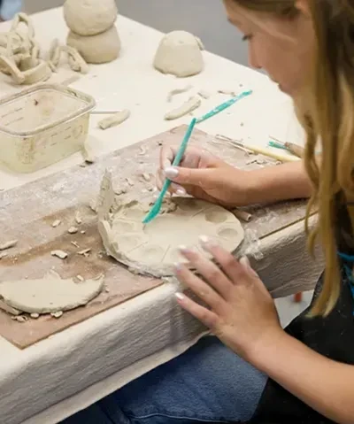 photo looking over the shoulder of student crafting at table