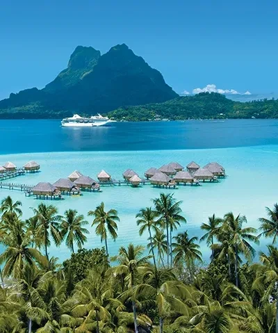 Bora Bora waters with bungalows and ship in background