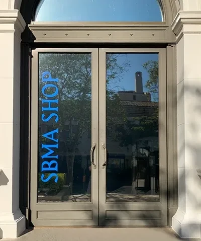 exterior of museum shop entry doors with sbma shop lettering on the glass