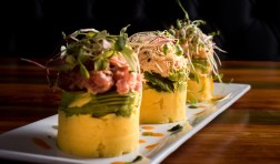 Traditional Peruvian dish called Causa made of mashed potato with aji hot pepper and lime juice and filled with vegetables corn, peas, carrots and mayonnaise 