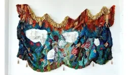 photo of colorful wall hanging surrounding sculptural objects